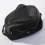 Black canvas and leather dopp kit opened showing striped interior.