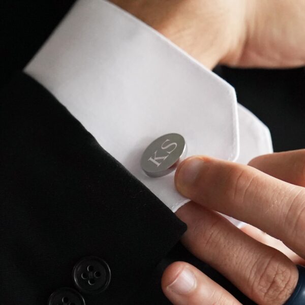 The best man wears a pair of oval cufflinks on the wedding day