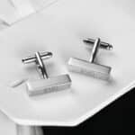 Silver rectangular cuff links worn with a white dress shirt