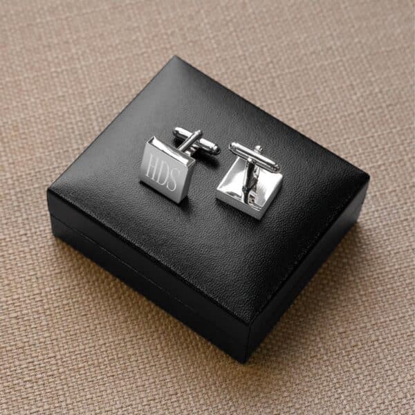 Silver square cuff links shown sitting on included storage box