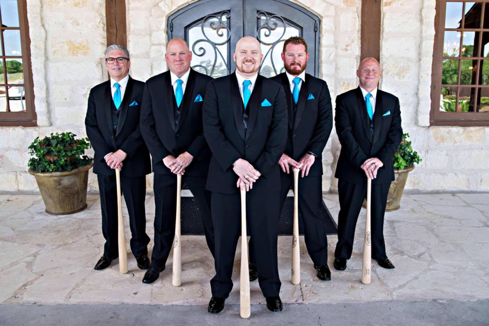 Wedding party groomsmen holding baseball bats