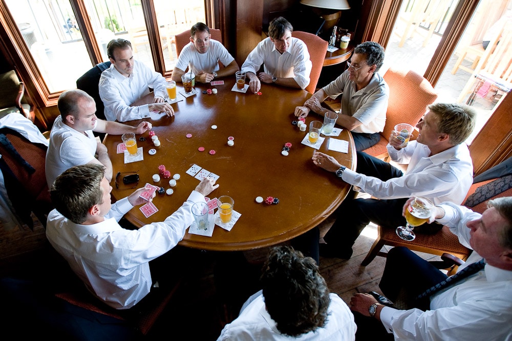 The groom plays poker with his groomsmen prior to the start of his wedding