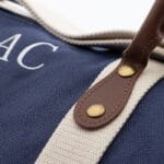 Leather accents and white strap on the blue groomsmen duffle bag