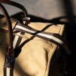 Khaki weekend duffle bag with padded zippered pockets and slip pocket