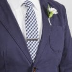 Groom in a blue suit with custom gunmetal tie clip