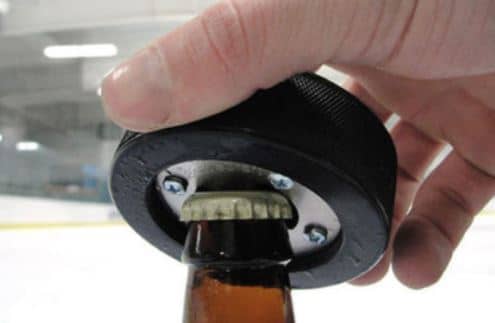 On one side of the puck is the NHL team logo. On the other side is a bottle opener.