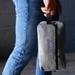 Grey dopp kit being carried by handle