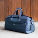 The Suit Saver v2 Bag shown in blue with custom ivory embroidery