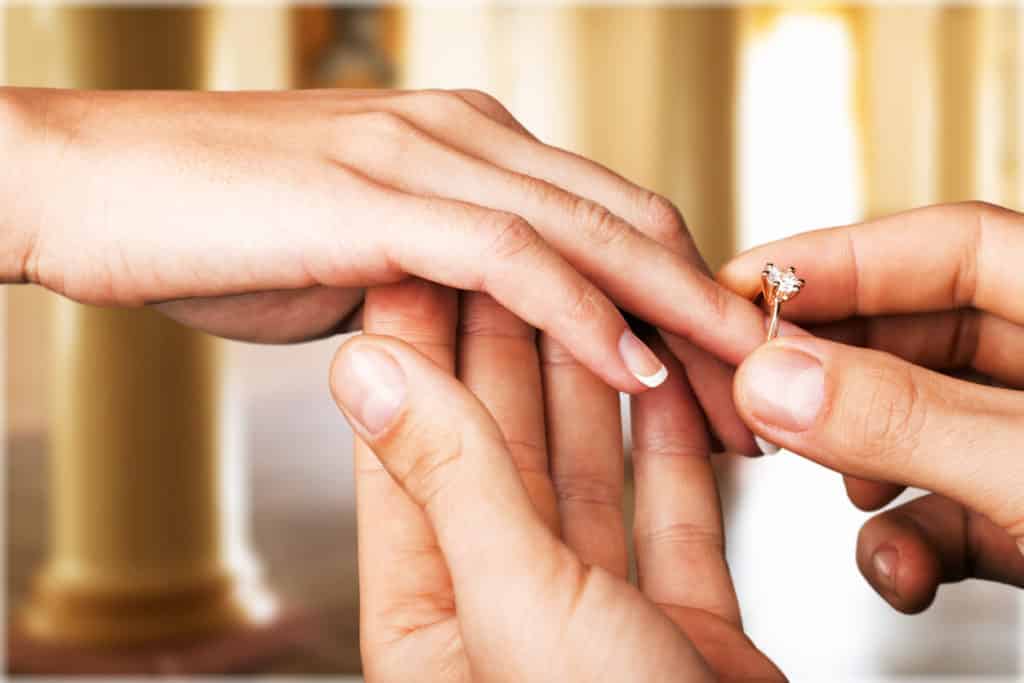 boyfriend putting the engagement ring on fiance