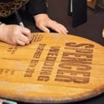 A wedding guest signing the Knob Creek wedding barrel.
