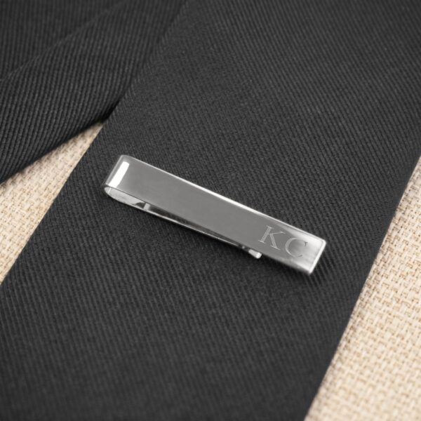 Silver tie clip paired with a black tie