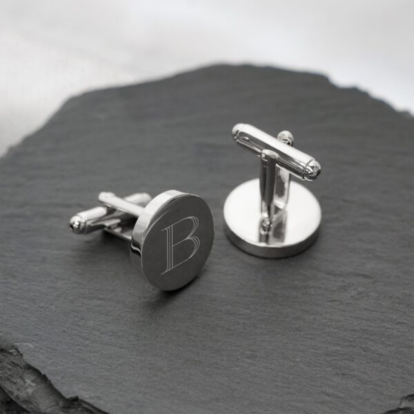 Round silver cuff links engraved with a single initial