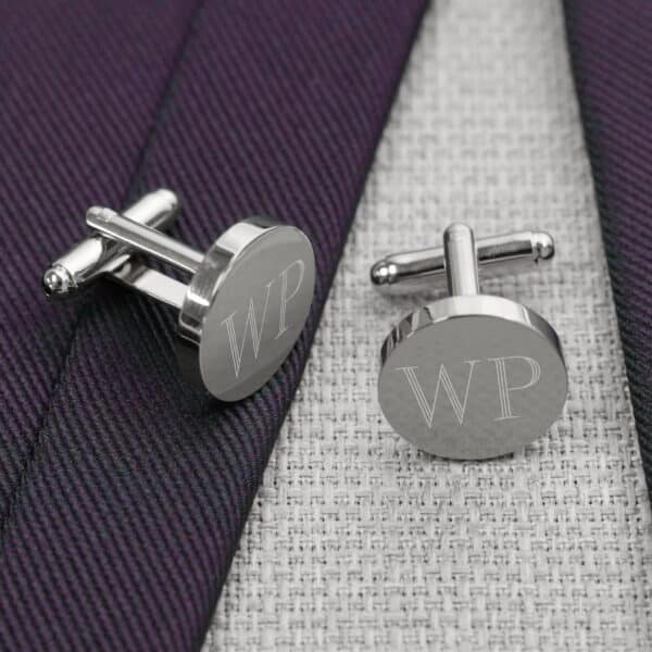 Round silver cufflinks pair with a blue tie