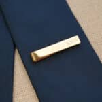 The gold tie clip is engraved with a name or initials for no extra cost