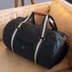 Black nylon duffle bag sitting on the couch in a hotel lobby
