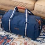 A blue nylon duffle bag packed up and ready for wedding travel
