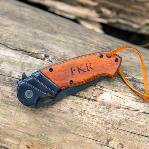 Wooden folding pocket knife shown closed with custom initials laser engraved on the wood handle
