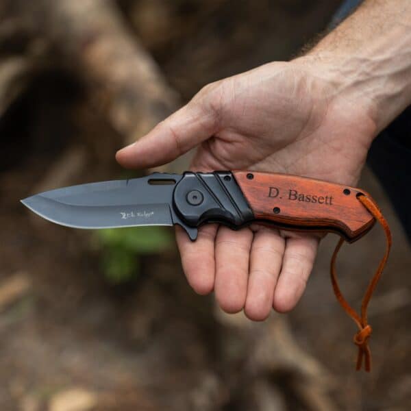 A man holding the wood pocket knife in a rustic forest setting