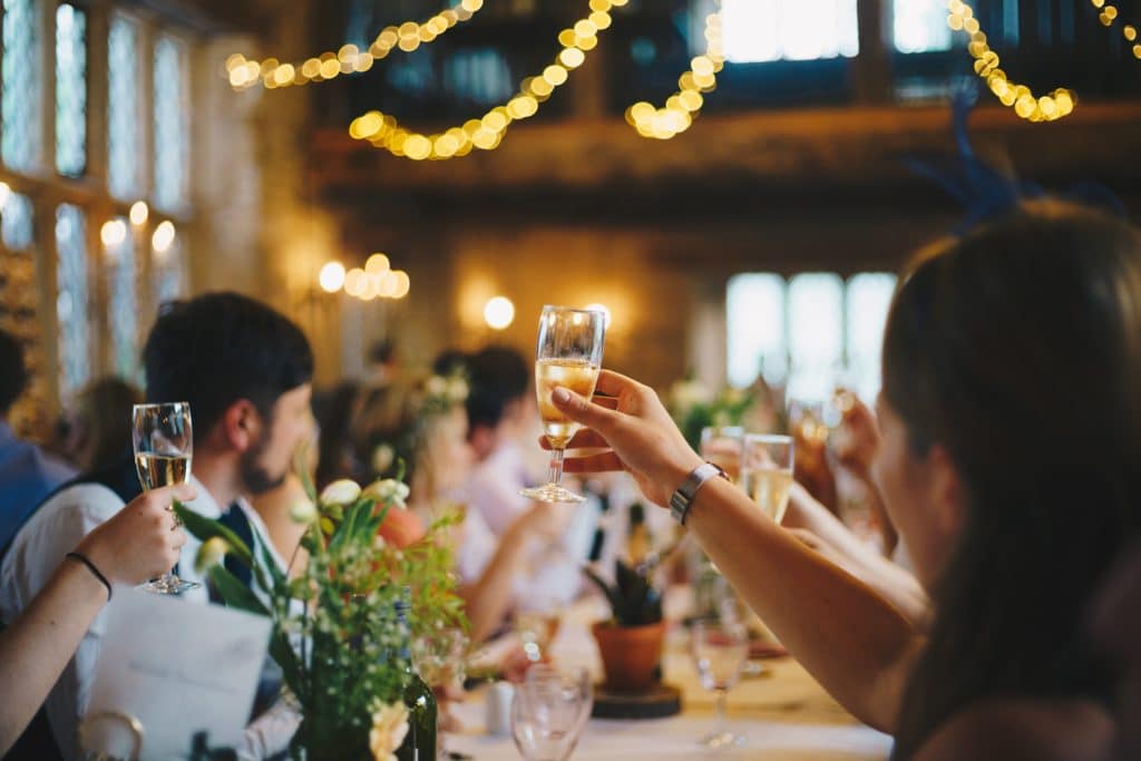 raising glasses at wedding rehearsal dinner