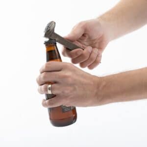 Using a railroad spike to open a beer bottle