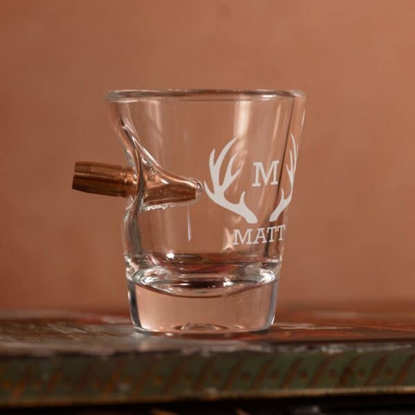 Empty shot glass with bullet
