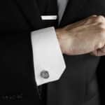 A groom wearing his silver beaded cufflinks and tie clip for his wedding