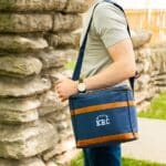 Man carrying a football-themed soft cooler over his shoulder