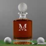Golf decanter show full of whiskey with custom split groomsmen monogram design laser engraved on front.