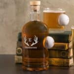 Glassware set featuring a decanter and rocks glass. Both pieces feature a Titleist golf ball "stuck" in the side.