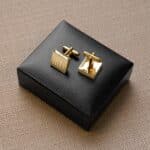 The gold square cufflinks are engraved with each groomsman's initials