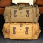 The green and khaki long weekend bags stacked in the trunk and ready for a road trip