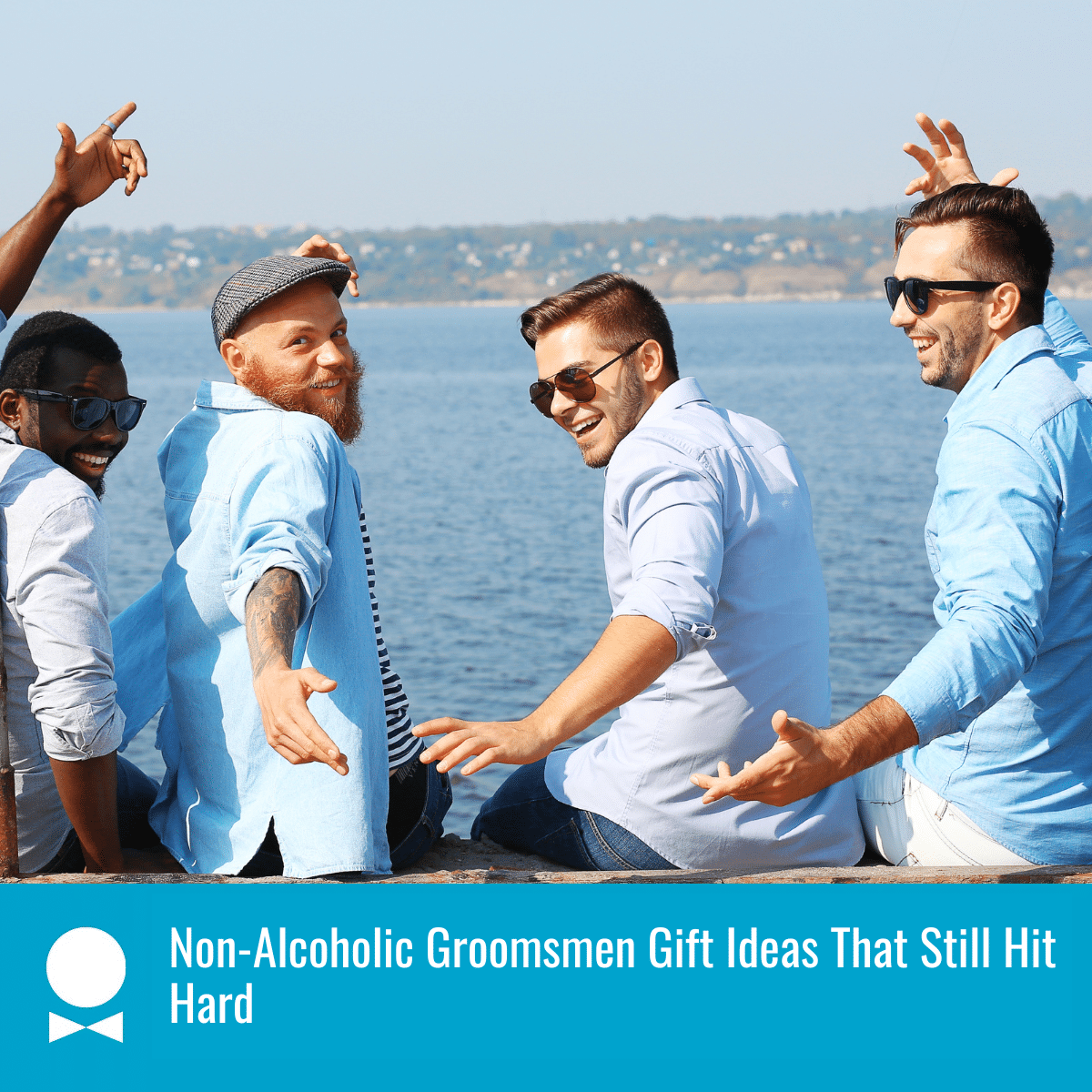 Four men with their hands in the air, sitting on rock ledge, overlooking a body of water. There is a textbox that reads "Non-Alcoholic Groomsmen Gift Ideas That Still Hit Hard"
