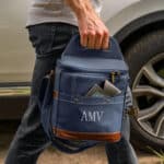 A man carrying a personal soft-sided blue cooler with custom embroidery of his initials.