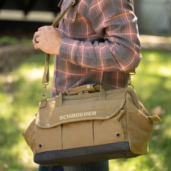 Man carrying green tool bag over his shoulder