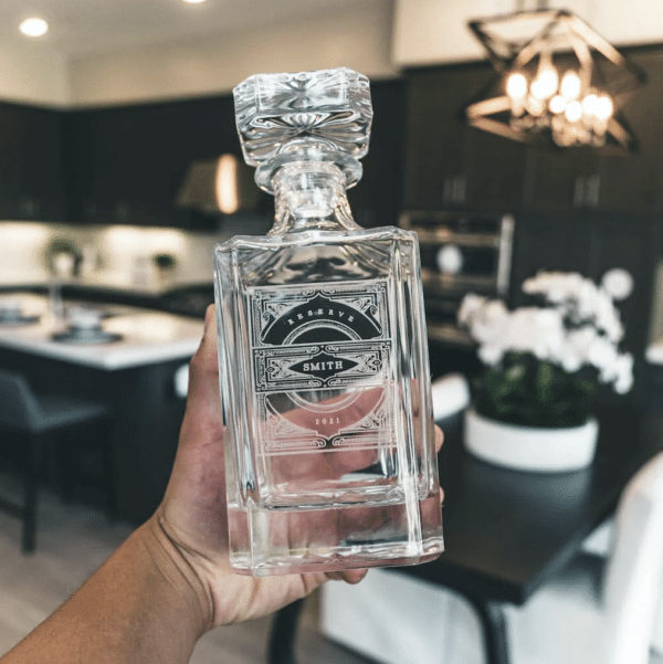 Groom holding an engraved custom decanter on the wedding day