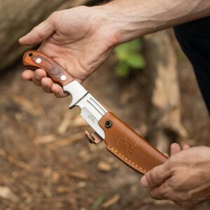 Elk Ridge Fixed Blade Knife showing being put in the accompanying brown leather sheath.