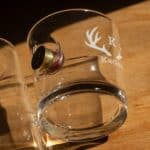 Custom engraved lowball glass with a shotgun shell casing sticking out the side