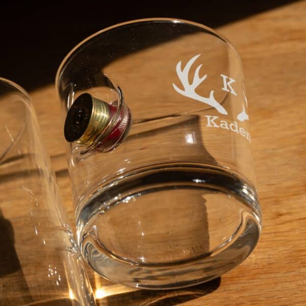 Custom engraved lowball glass with a shotgun shell casing sticking out the side