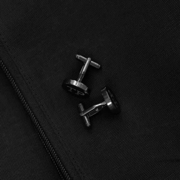 Gunmetal round round cufflinks set against a black suit