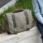 Man sitting outside on a concrete stoop with his briefcase next to him
