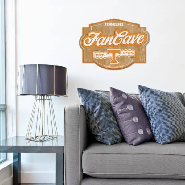 NCAA Fan Cave Sign shown hanging in a living room above a couch.