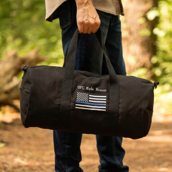 Holding the police tactical bag by it's top carry handles