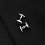 Silver round cufflinks set against a black suit