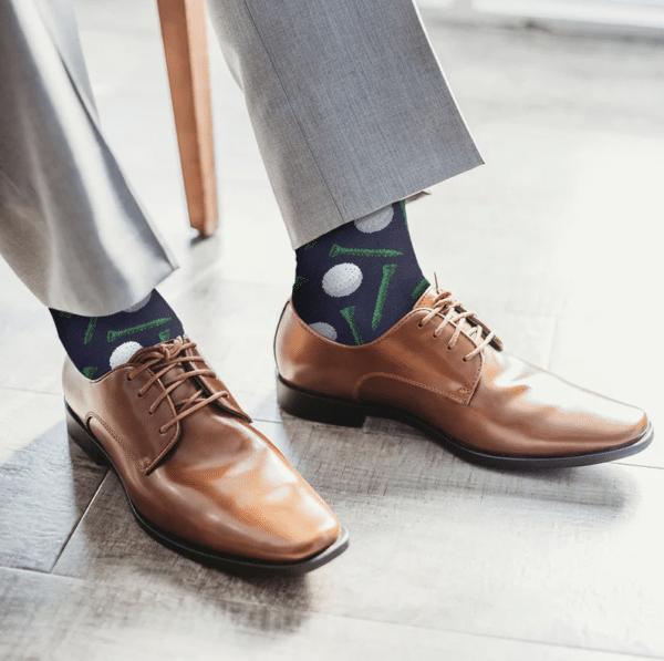 The groom putting on his golf socks before the wedding